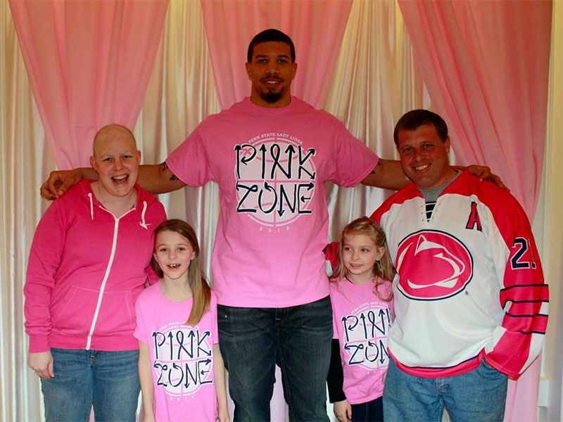 Pink Zone volunteer posing with survivor family